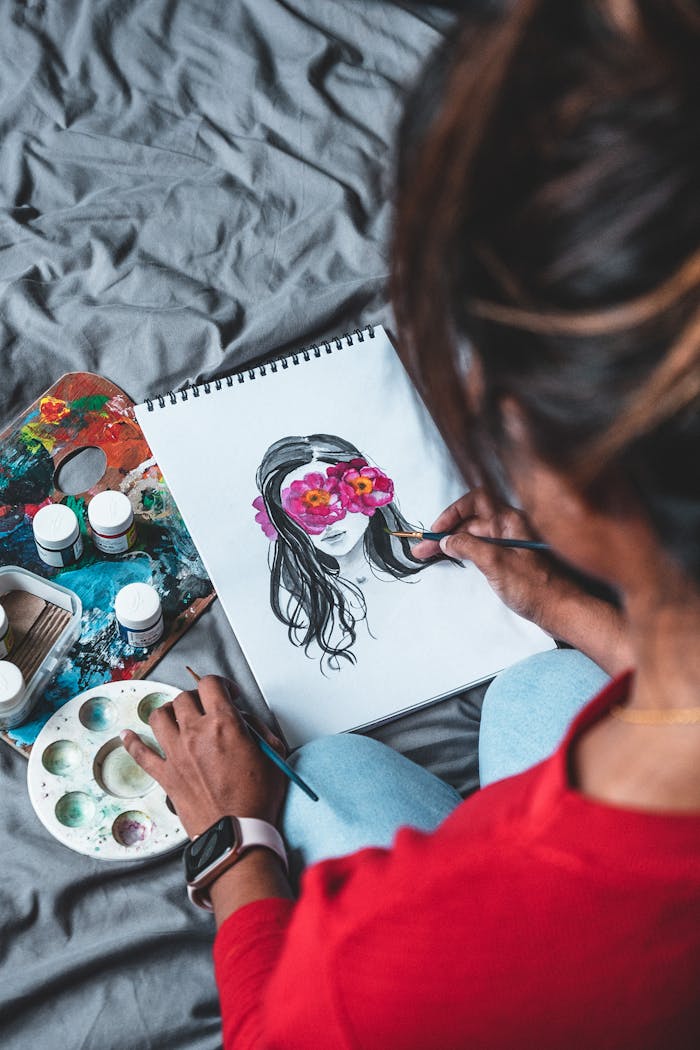 Artist focused on painting a floral portrait sketch using vibrant colors indoors.